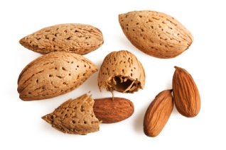 almonds in their shell and cracked open and outside of their shell for skin and health benefits
